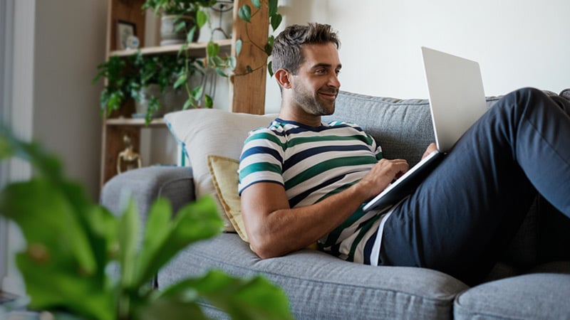 man with computer on couch