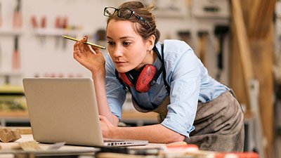 Mujer carpintera mirando a su notebook
